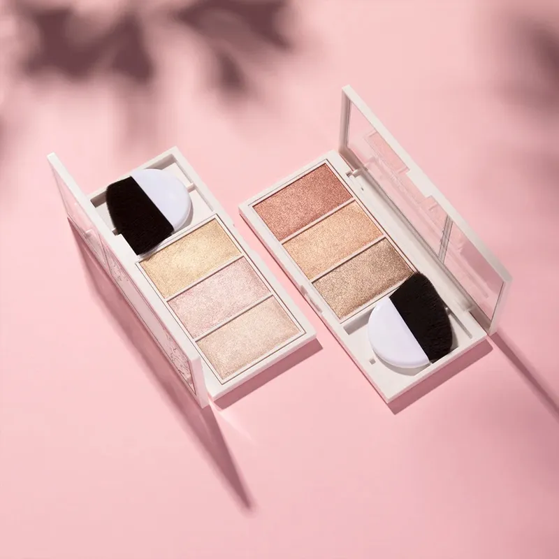 Two makeup palettes with brushes on a pink background