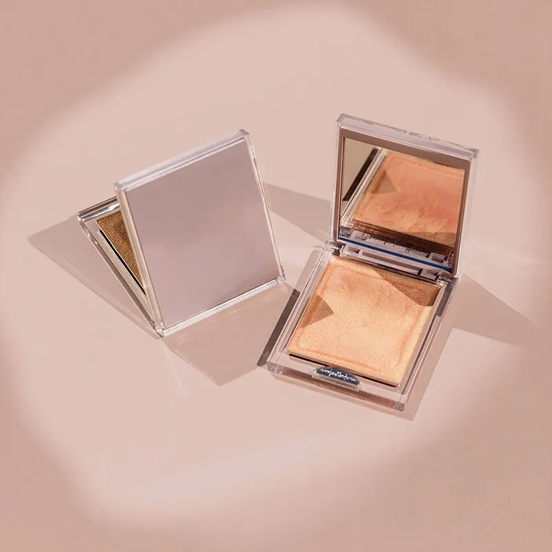 Two compact highlighters with mirrors on a flat surface.