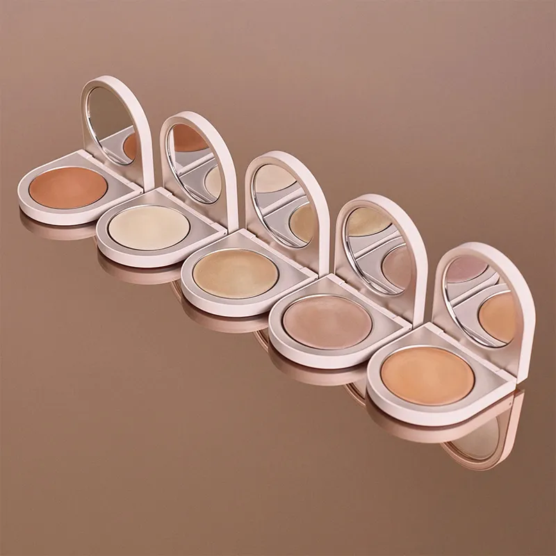 Five open compact highlighter cases with mirrors in different shades arranged in a row.