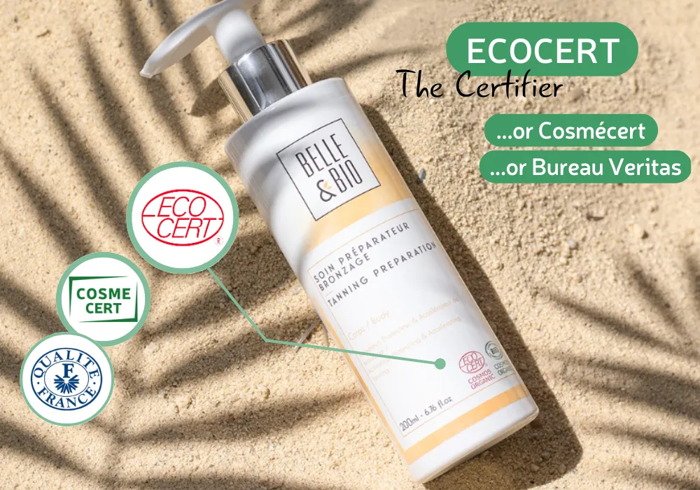 Un flacone di preparato abbronzante Belle & Bio su sabbia con i loghi Ecocert, CosmeCert e Qualite France.