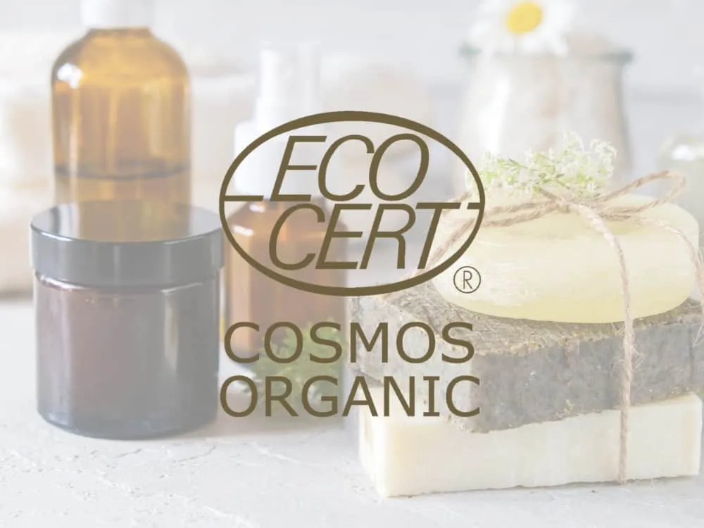 Logo Ecocert Cosmos Organic sovrapposto a prodotti cosmetici naturali.
