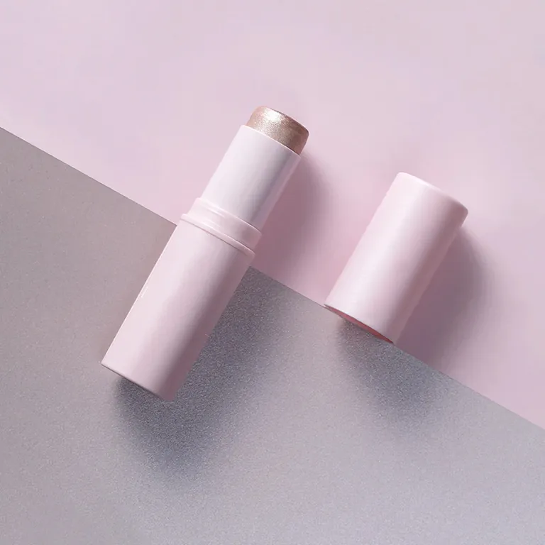 A pink highlighter stick and its cap on a two-toned background.