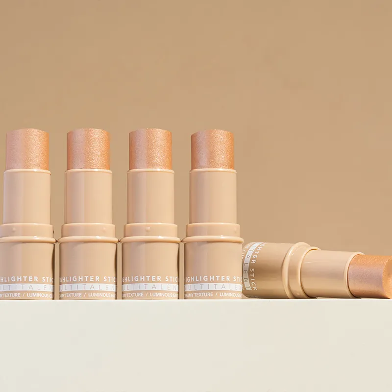 Five beige highlighter sticks with shimmering tops arranged in a line on a light surface.
