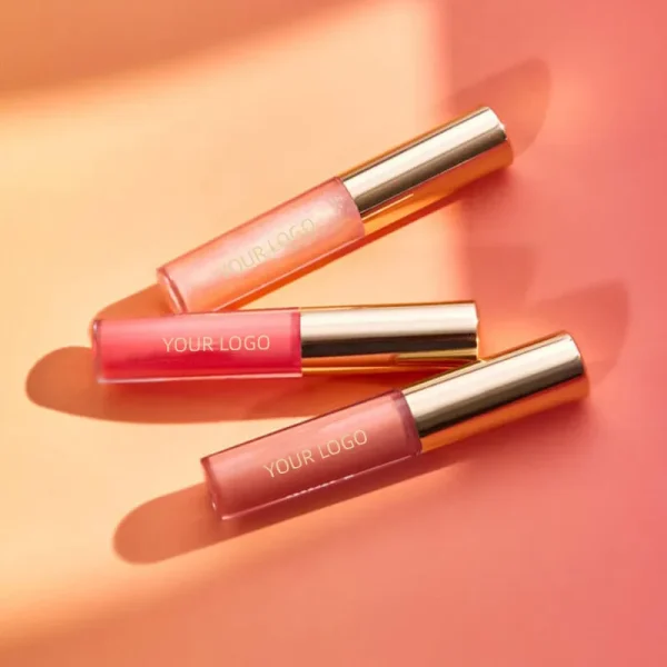 Three lip gloss tubes arranged on a pink surface, each with a golden cap.