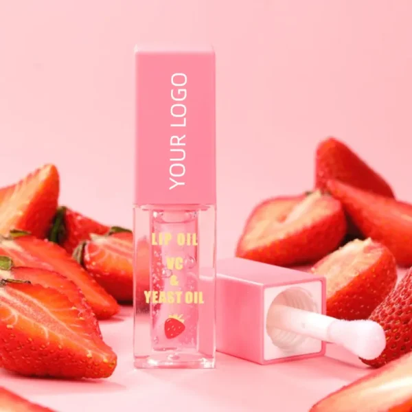 pink and clear lip oil container labeled 'lip oil vc yeast oil' surrounded by sliced strawberries on a pink background