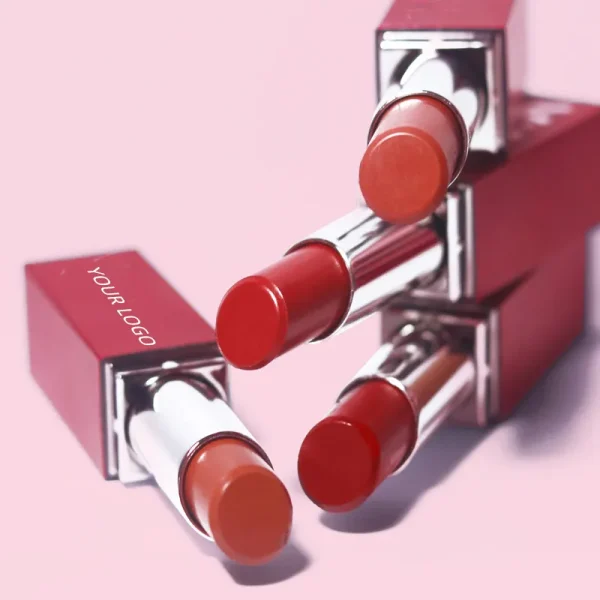 Four red Tinted Lip Balm positioned creatively against a pink background.