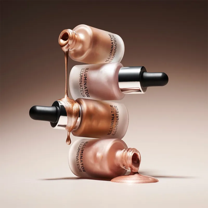 Three open bottles of liquid illuminator stacked with product flowing out