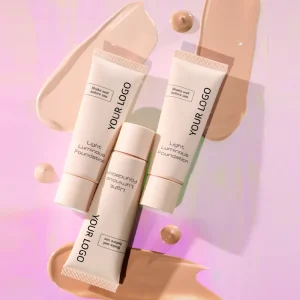 Light Luminous Foundation with 'Your Logo' text on them, placed on a pink surface with foundation smears and drops.