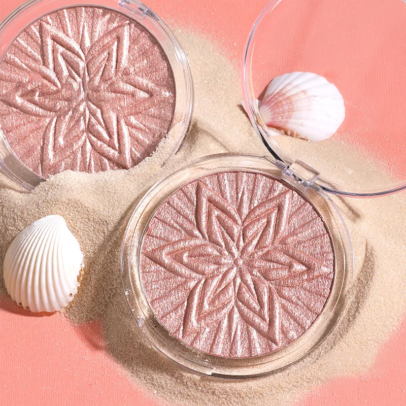 Two compacts with embossed star patterns on a sandy surface with seashells.