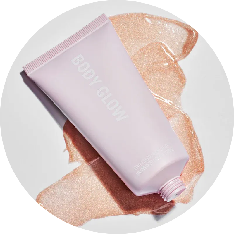 A pink tube labeled 'Body Glow' with its contents spread around.