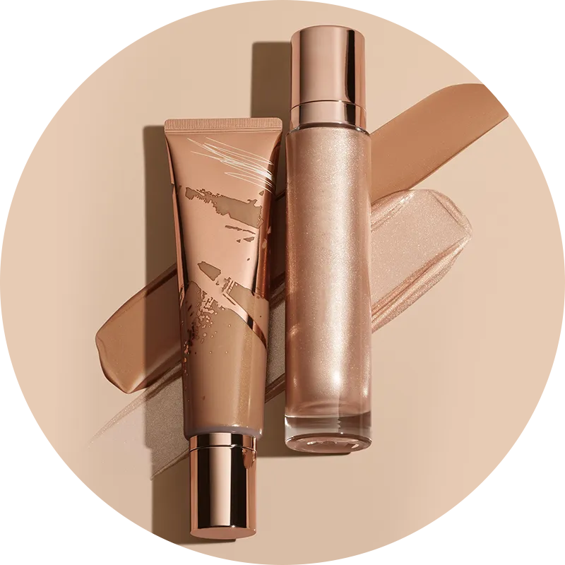 Two cosmetic products with rose gold caps on a beige background showing makeup swatches.