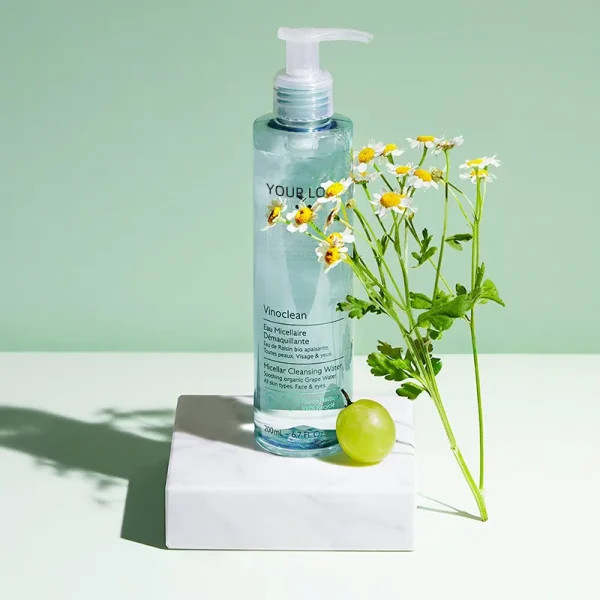 A bottle labeled Vinoclean Micellar Cleansing Water with a grape and flowers on a light green background.