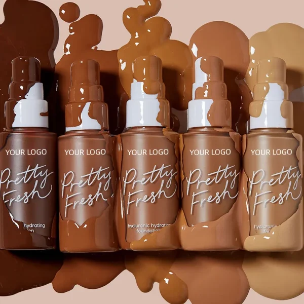 Five bottles of Pretty Fresh hyaluronic hydrating foundation in various shades, with foundation splattered behind them.