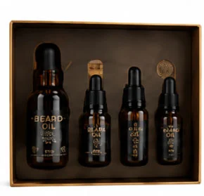 Beard oil gift set in brown packaging with four dark amber bottles labeled with oil types and dropper caps for grooming care.