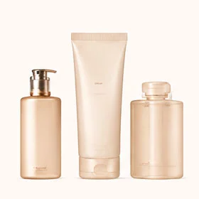 Three minimalist beauty product containers in neutral beige tones, including a pump bottle, a tube, and a capped bottle.