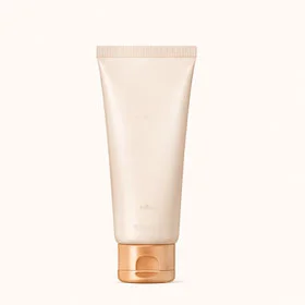 A minimalist, beige skincare tube with a golden flip-top cap on a neutral background.